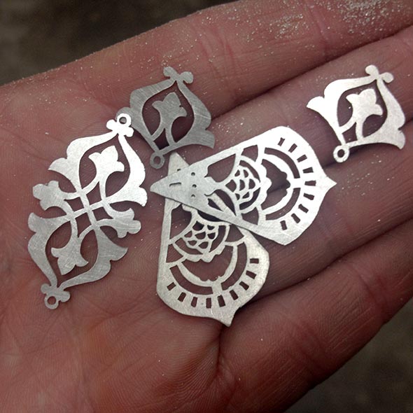 Jewellery components sawn out of sterling silver sheet by hand using a very fine jeweller's saw blade. These pieces are yet to be filed and sanded.